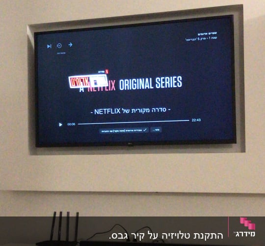 טלוויזיה תלויה על הקיר עם נתב ומזגן